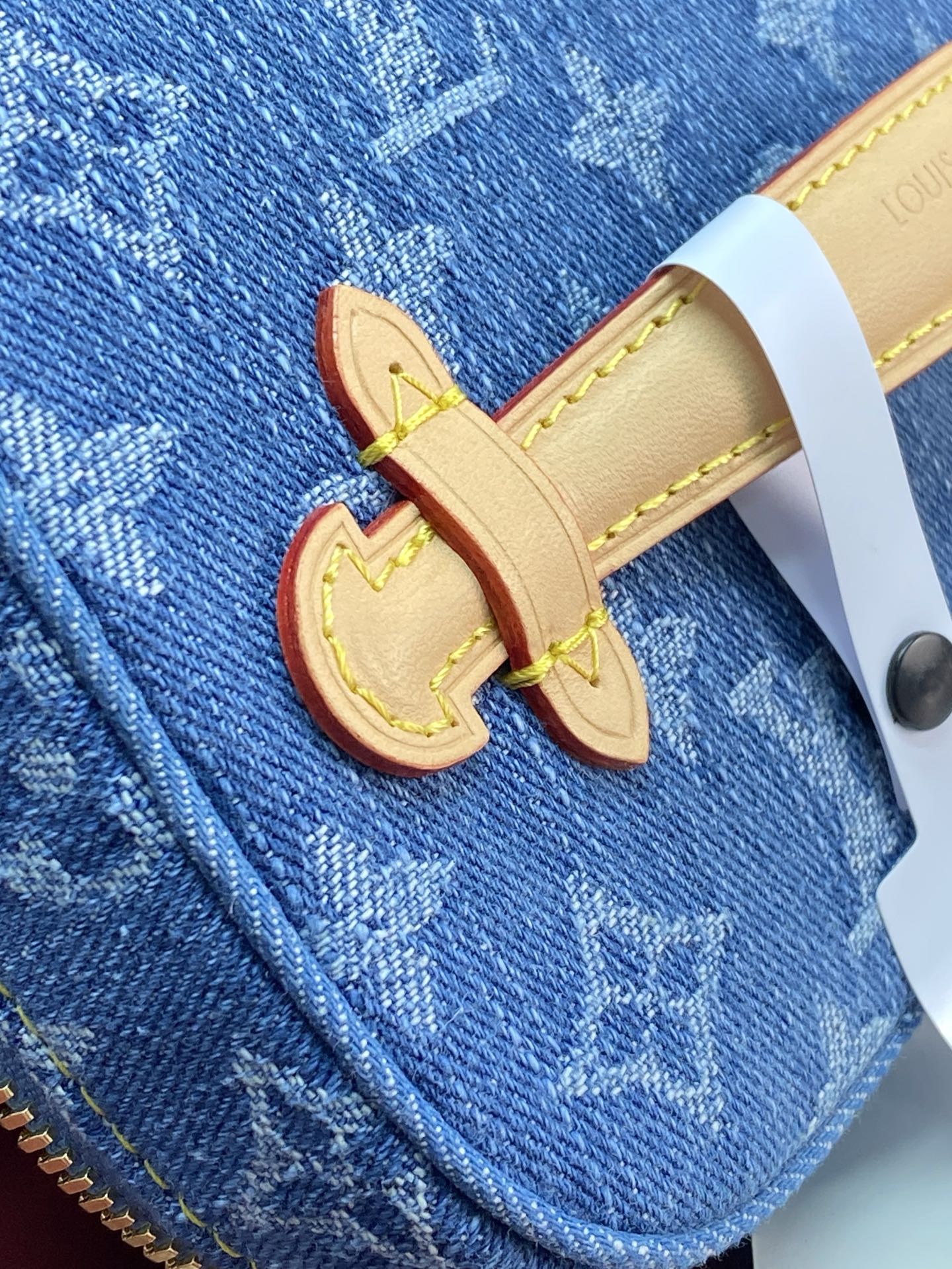 Louis Vuitton denim bag with beige leather strap and LV monogram patch
