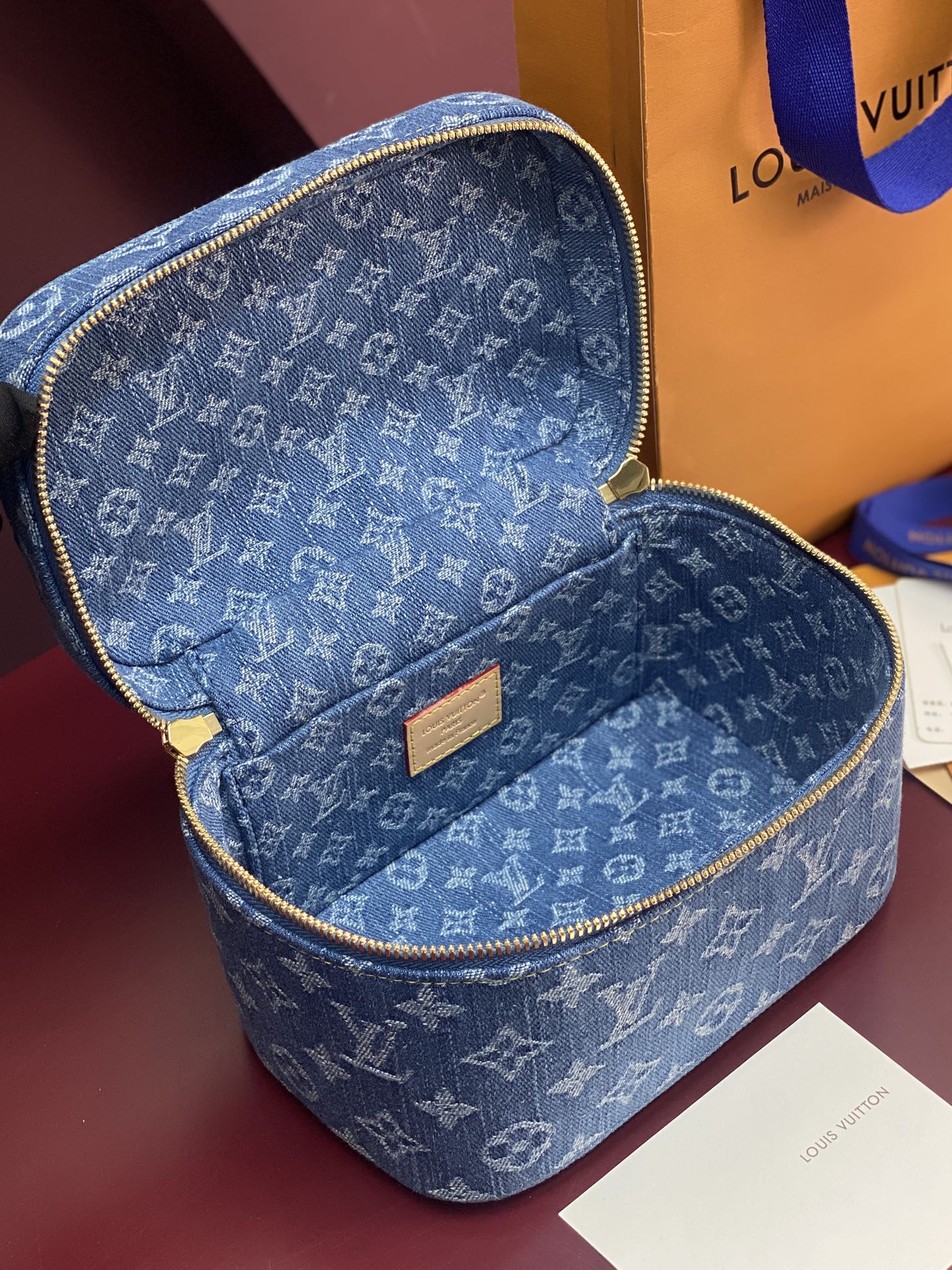 Louis Vuitton blue monogram vanity bag open, shows tan label and interior lining