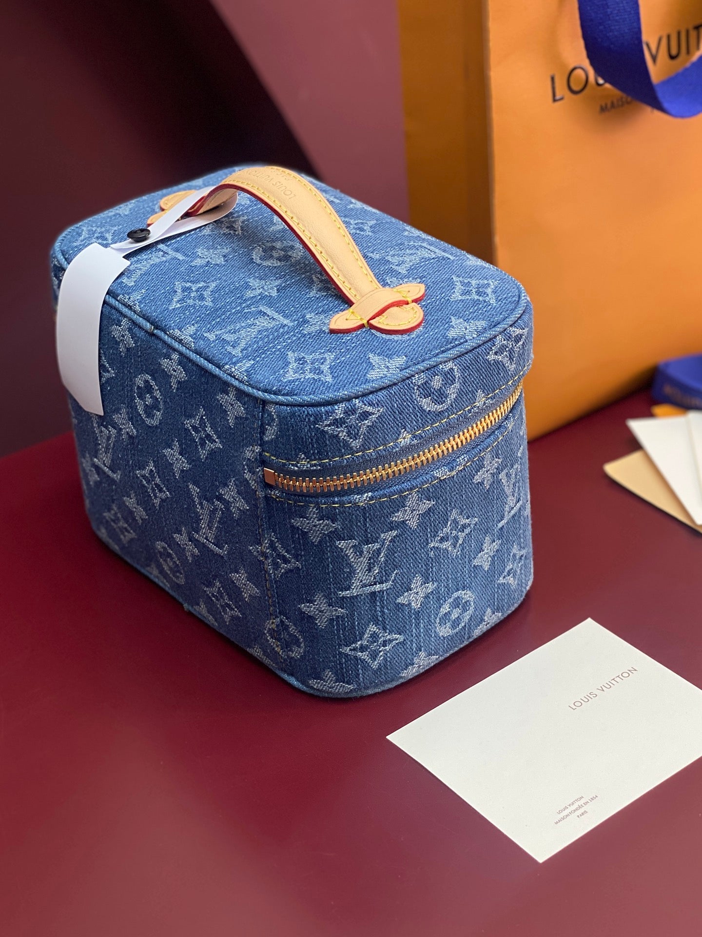 Louis Vuitton blue monogram mini vanity bag, front view, gold zipper trim