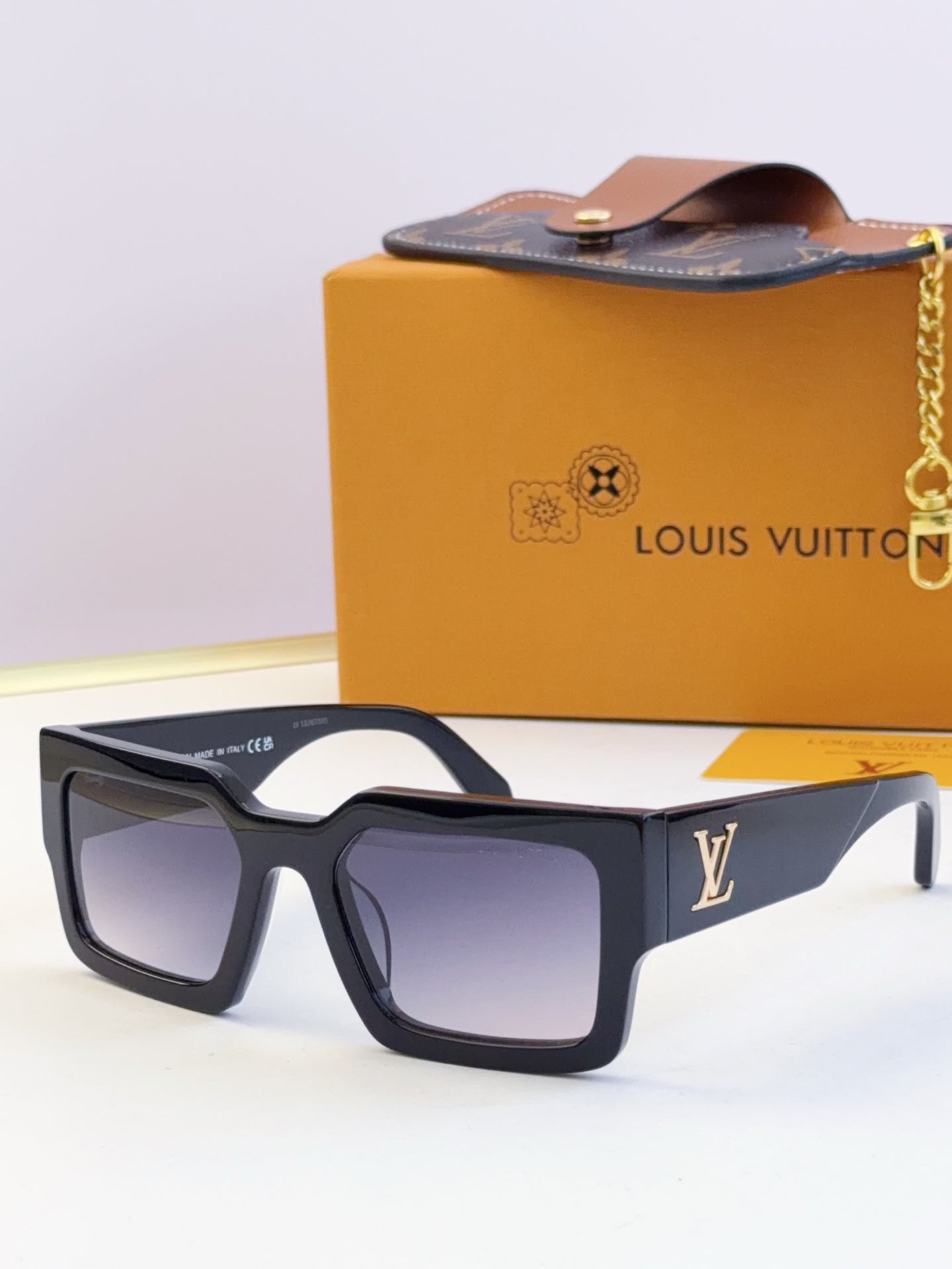 Louis Vuitton sunglasses with dark blue square frames and dark lenses, LV logo on temple.