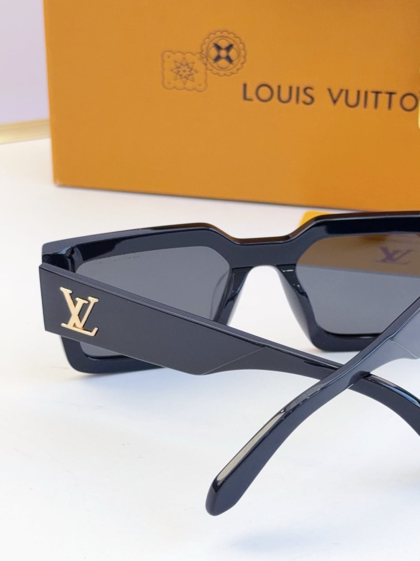 Louis Vuitton sunglasses with dark blue frames and LV monogram on the side arm.