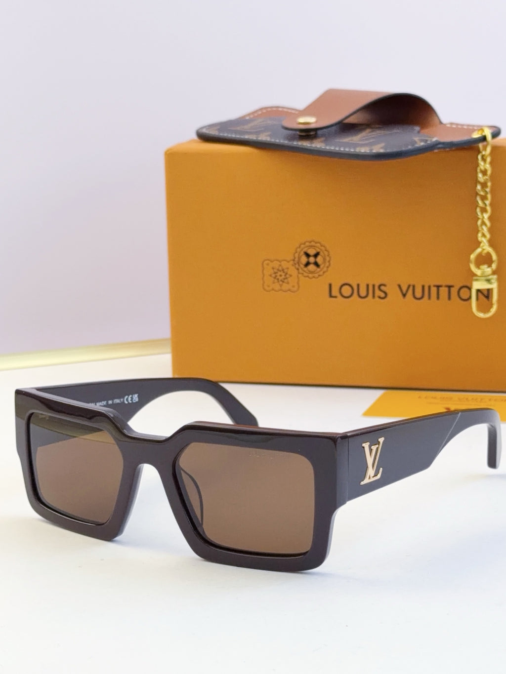 Louis Vuitton sunglasses with dark blue square frames and tinted lenses, LV logo on temple.