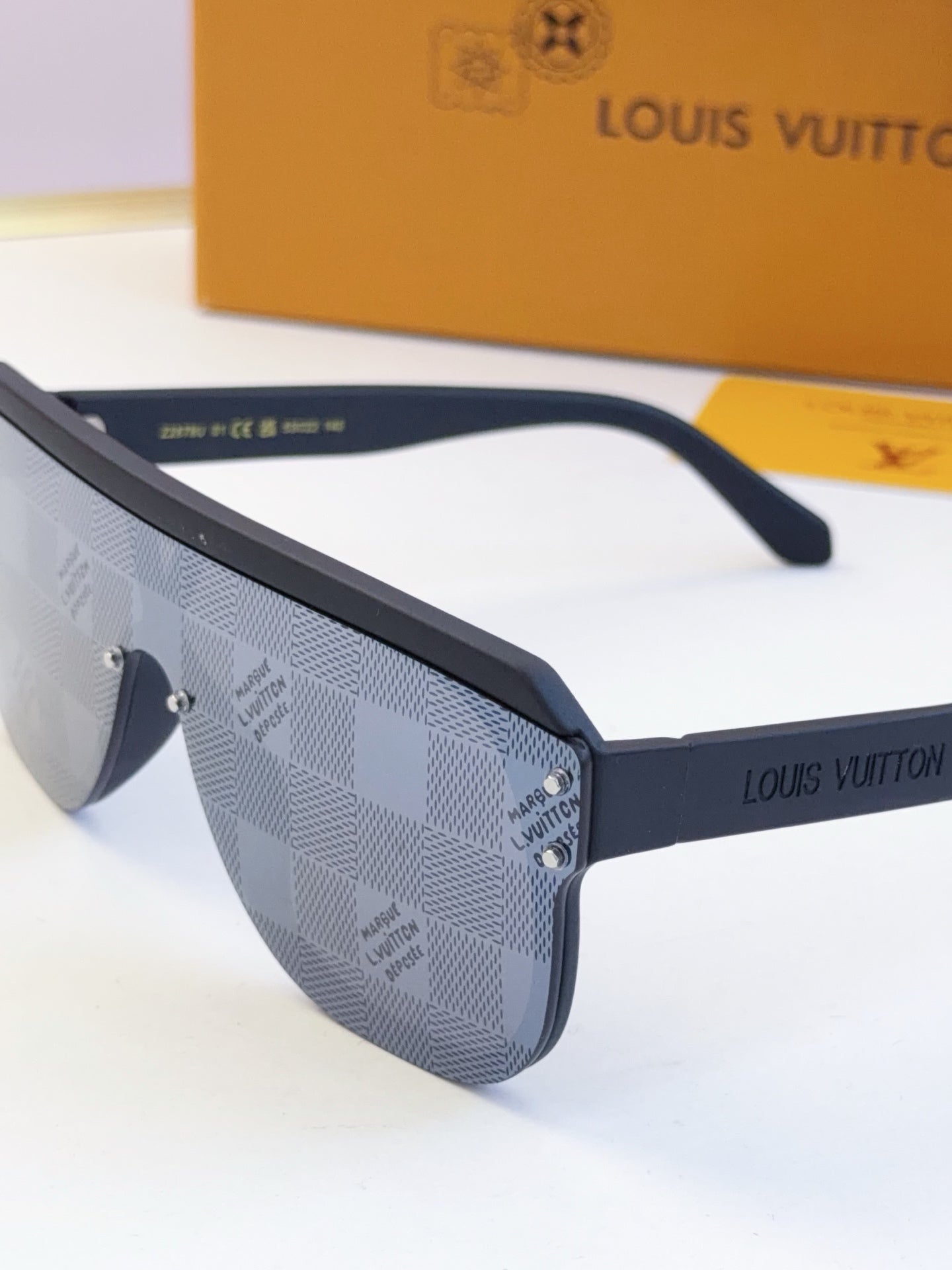 Blue patterned sunglasses with dark arms and logo label on the temple