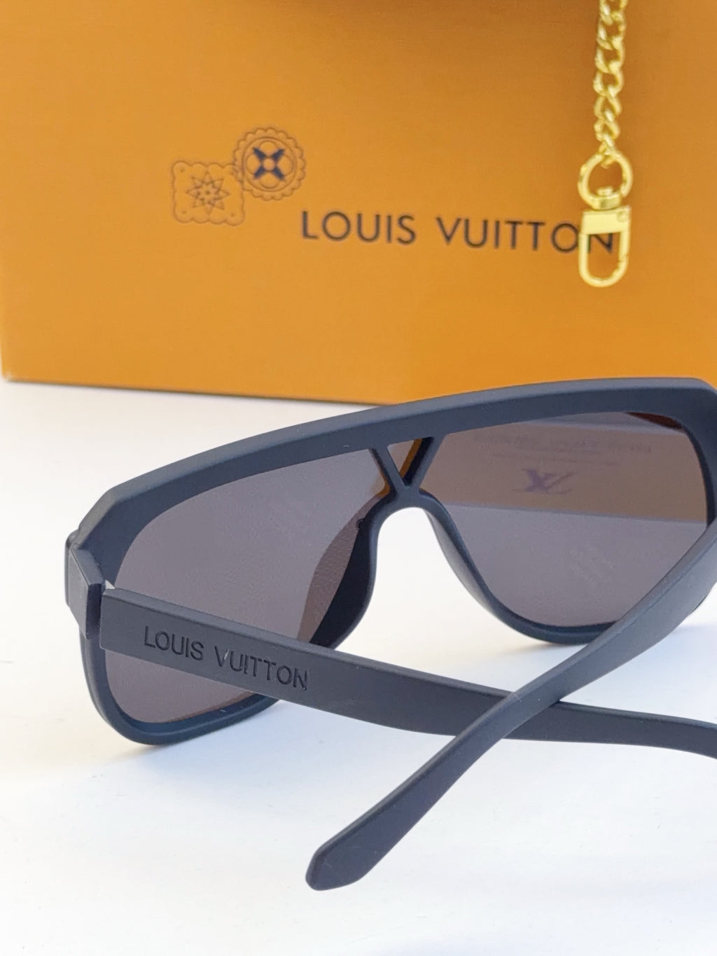 Blue sunglasses with purple tinted lenses and logo text on the temple