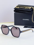 Chanel dark blue square sunglasses with purple-tinted lenses and gold chain detail