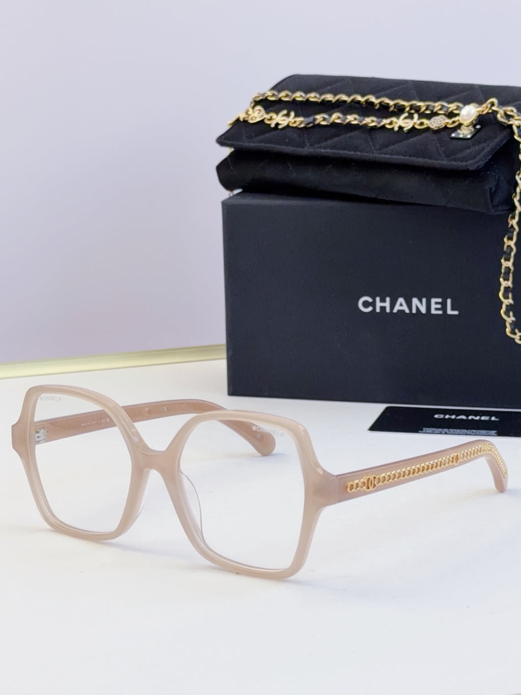 Chanel light beige square glasses with clear lenses and gold chain detail on arms