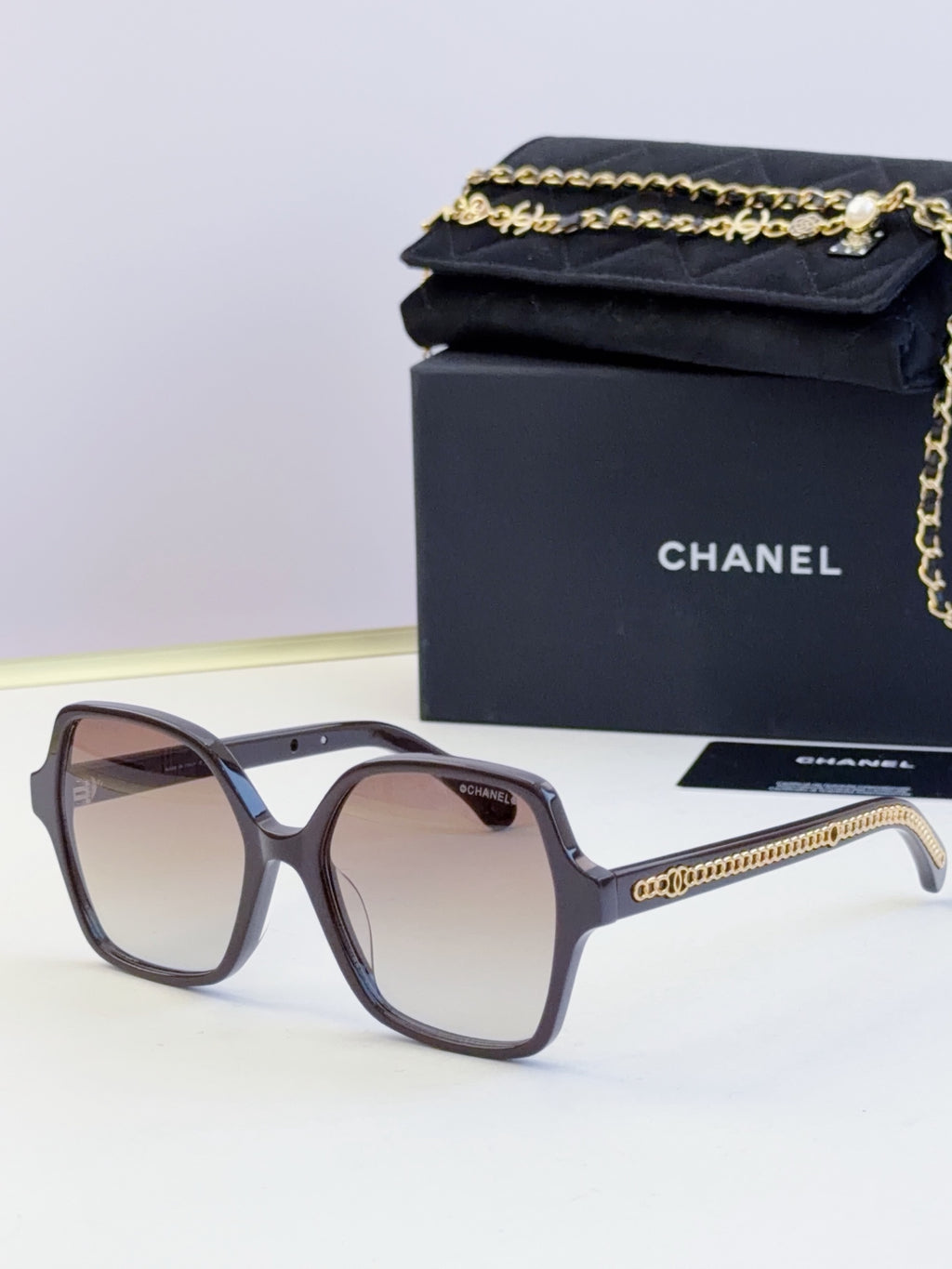 Chanel gray-blue square glasses with tinted lenses and gold chain detail
