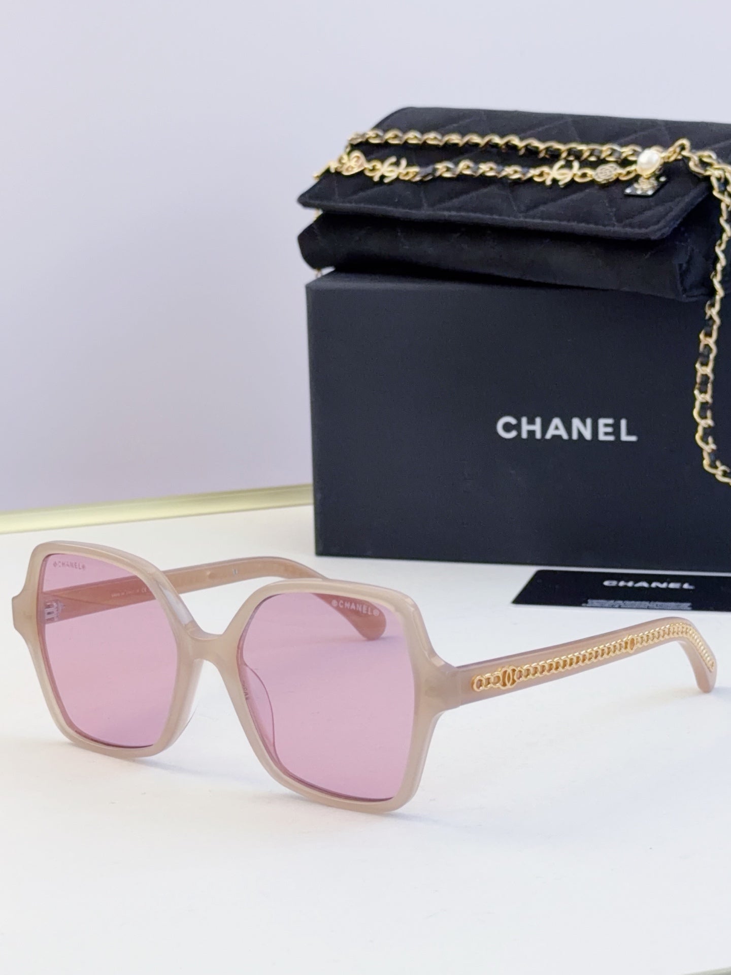 Chanel light pink square sunglasses with pink-tinted lenses and gold chain trim