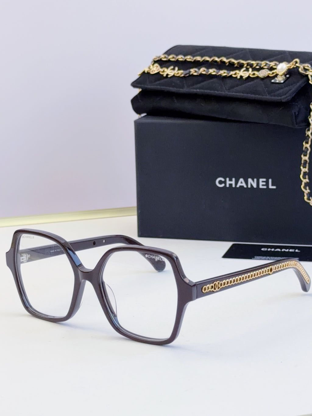 Chanel dark navy square glasses with clear lenses and gold chain on arms