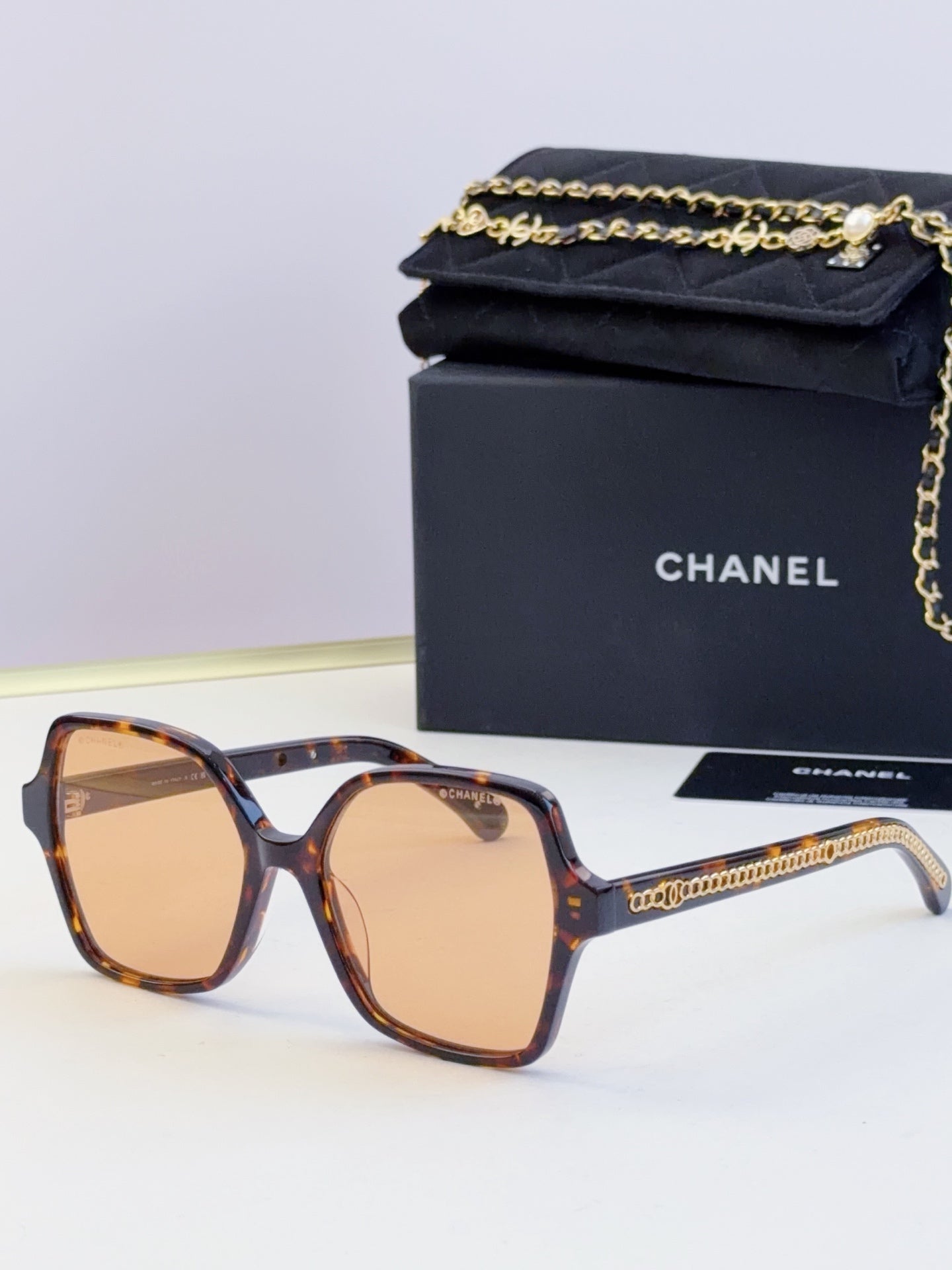 Chanel tortoiseshell square sunglasses with tan lenses and gold chain on side arms