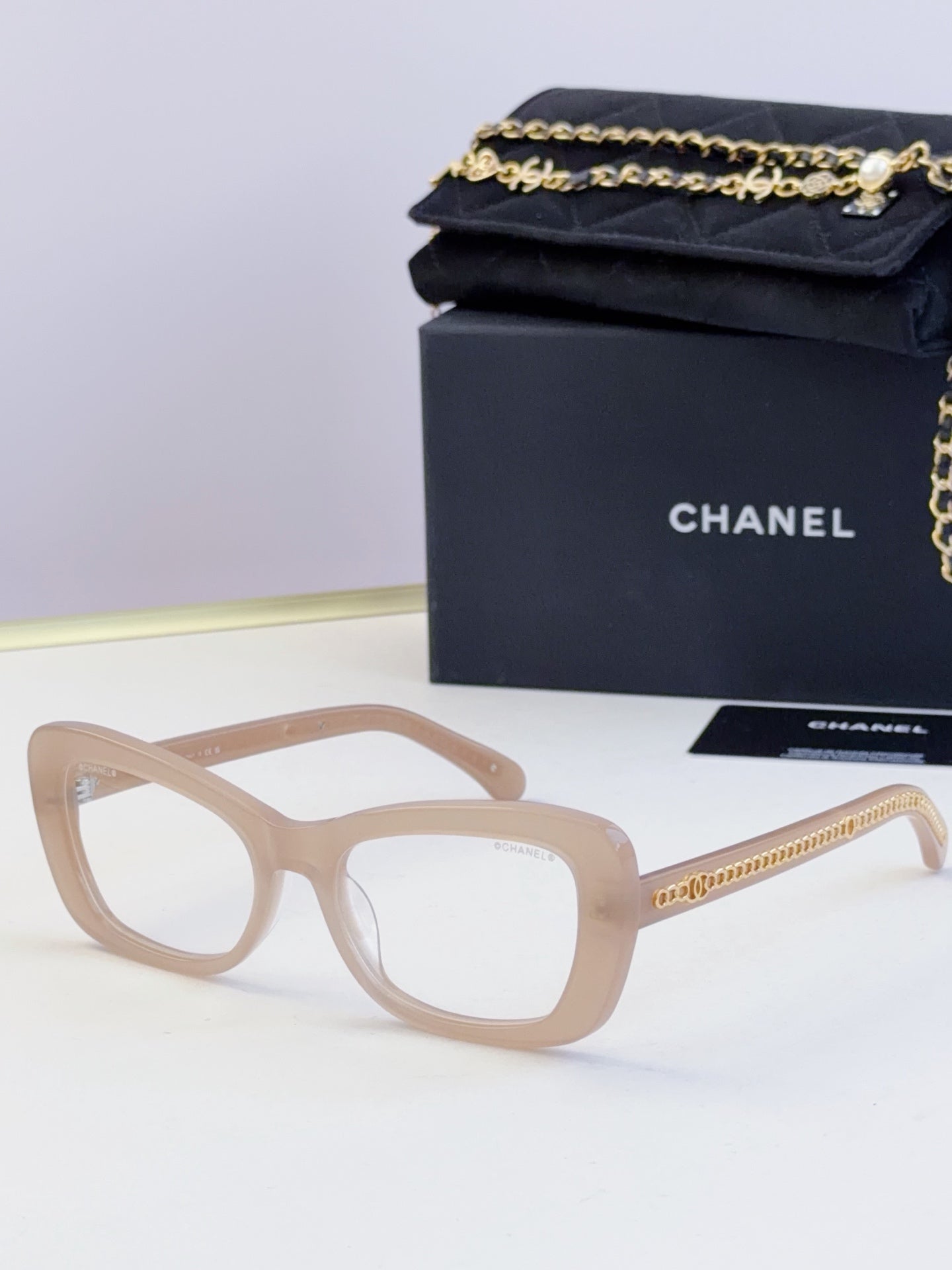 Light tan glasses with oversized square frames and clear lenses