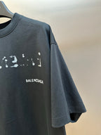 Balenciaga T-shirt sleeve and chest BALENCIAGA print on dark gray fabric.