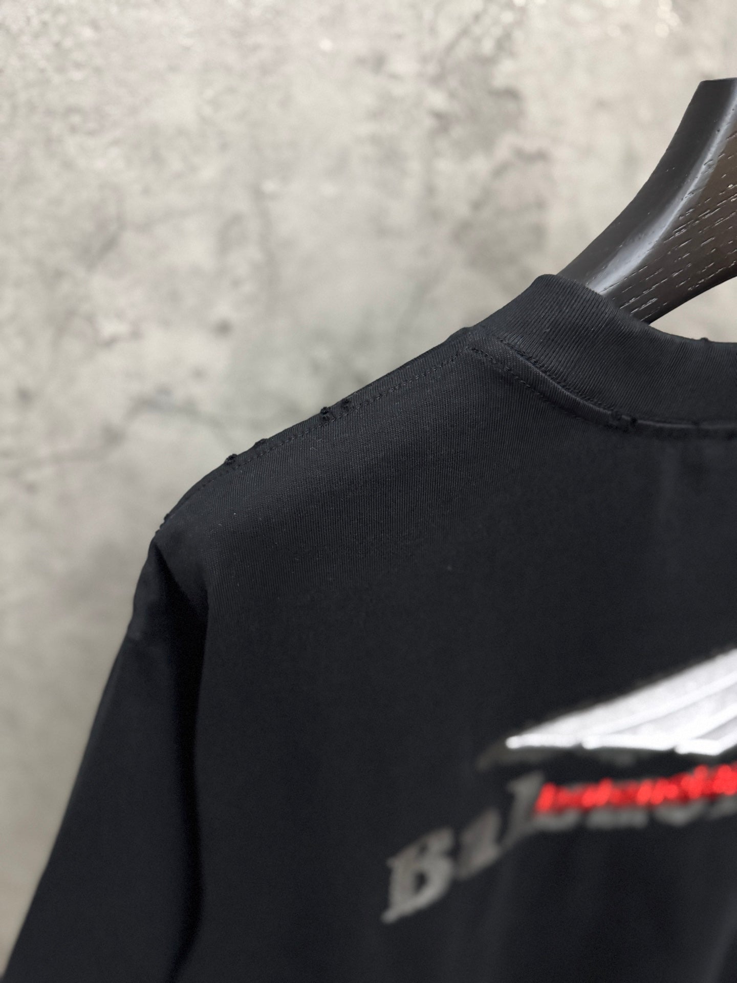 Black T-shirt with partial Balenciaga logo visible near shoulder