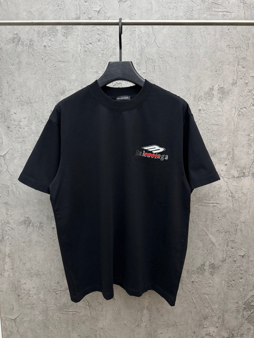 Black crewneck T-shirt with small graphic logo on left chest