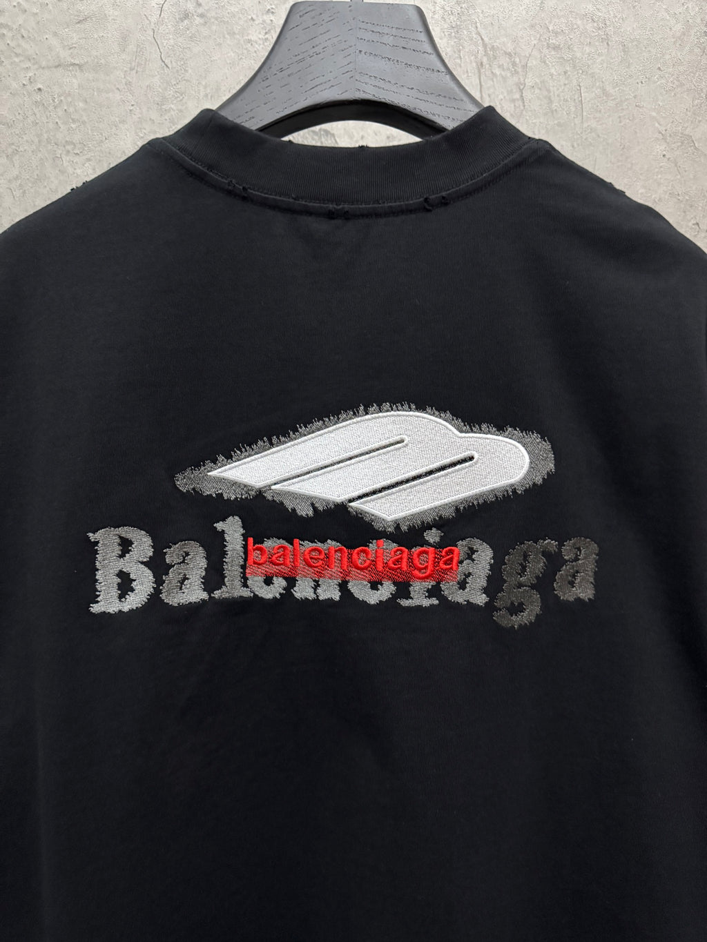 Black T-shirt with large white and red Balenciaga logo across chest