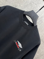Black crewneck T-shirt with small chest logo detail and neckline close-up