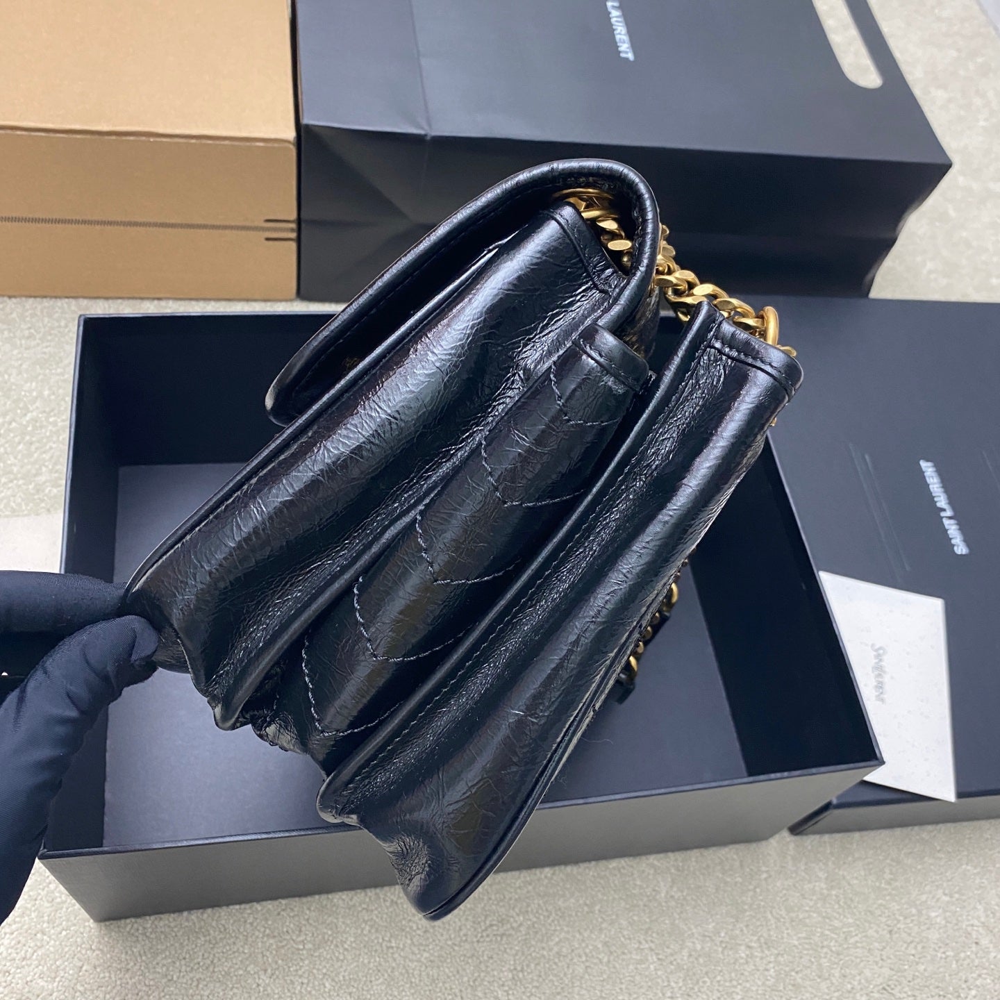 YSL leather shoulder bag, dark blue, side view with gold chain strap and hardware
