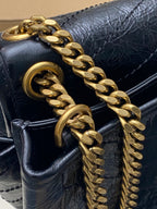 YSL chain strap detail on dark blue leather bag, gold hardware link accents