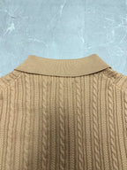 Beige knit polo shirt back with ribbed collar and vertical cable pattern.