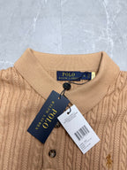 Beige knit polo shirt neckline with button placket and attached Polo Ralph Lauren tag.