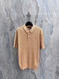 Beige knit polo shirt with ribbed collar and button placket, short sleeves.