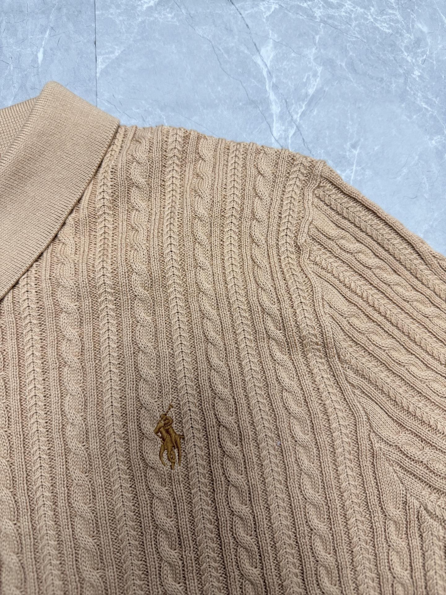 Beige knit polo shirt with cable-knit pattern and small embroidered pony logo.