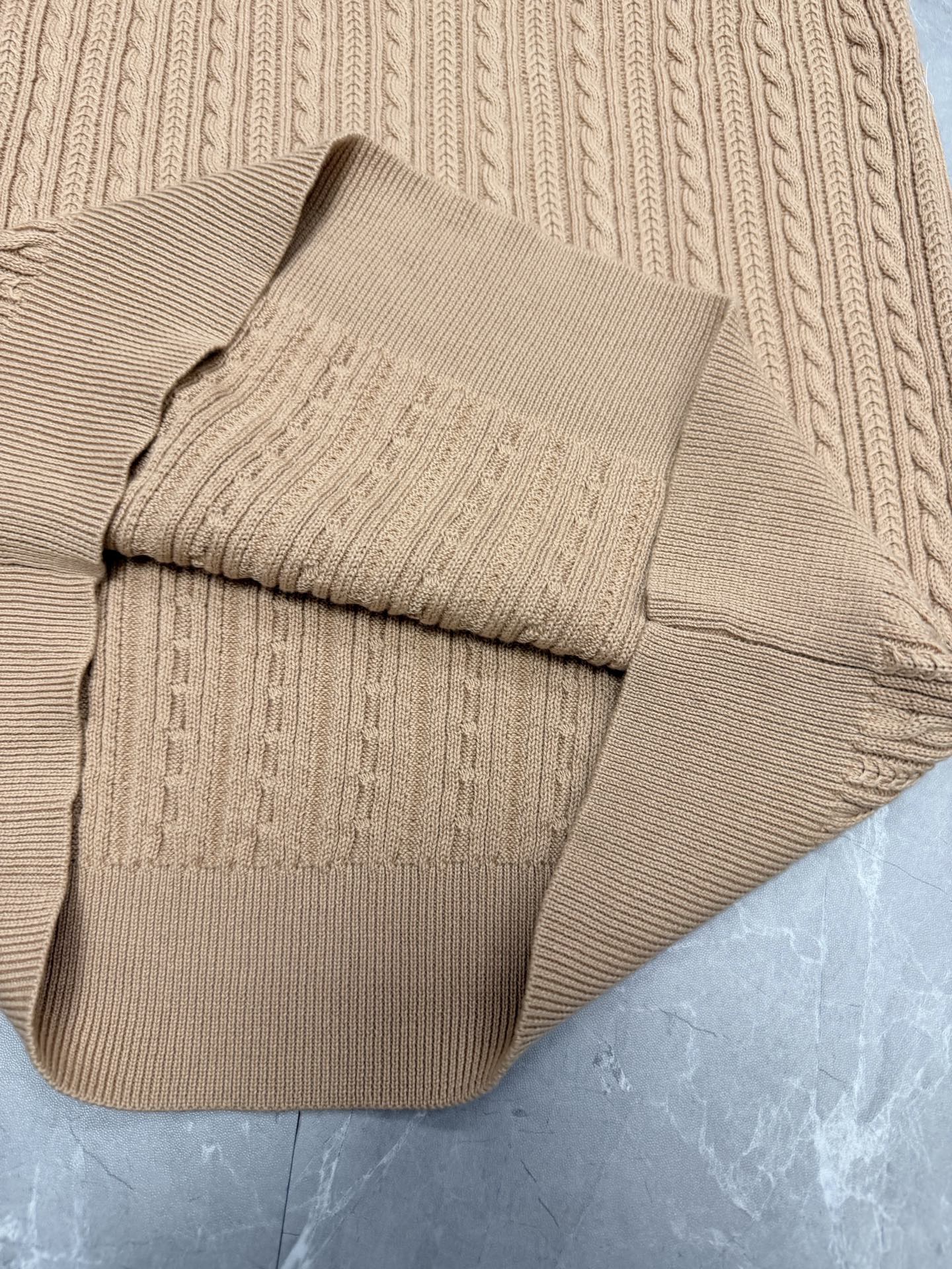Beige knit polo shirt hem panel with ribbed trim and cable knit detailing.
