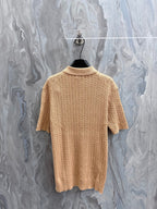 Beige knit polo shirt with ribbed crew collar and vertical cable texture, short sleeves.