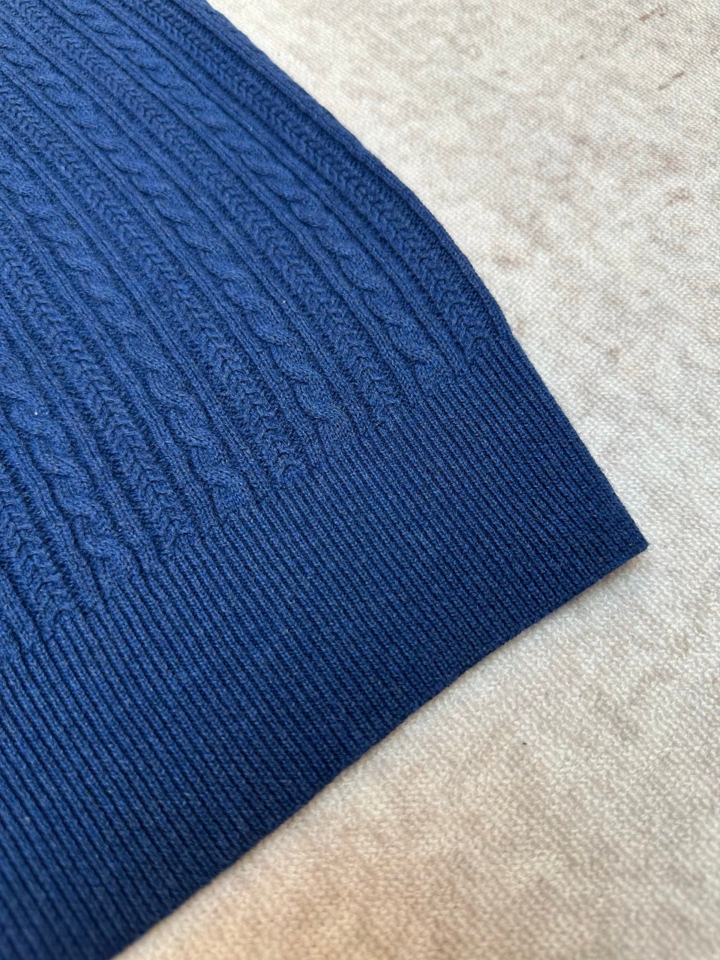Blue ribbed knit polo shirt sleeve and textured fabric detail