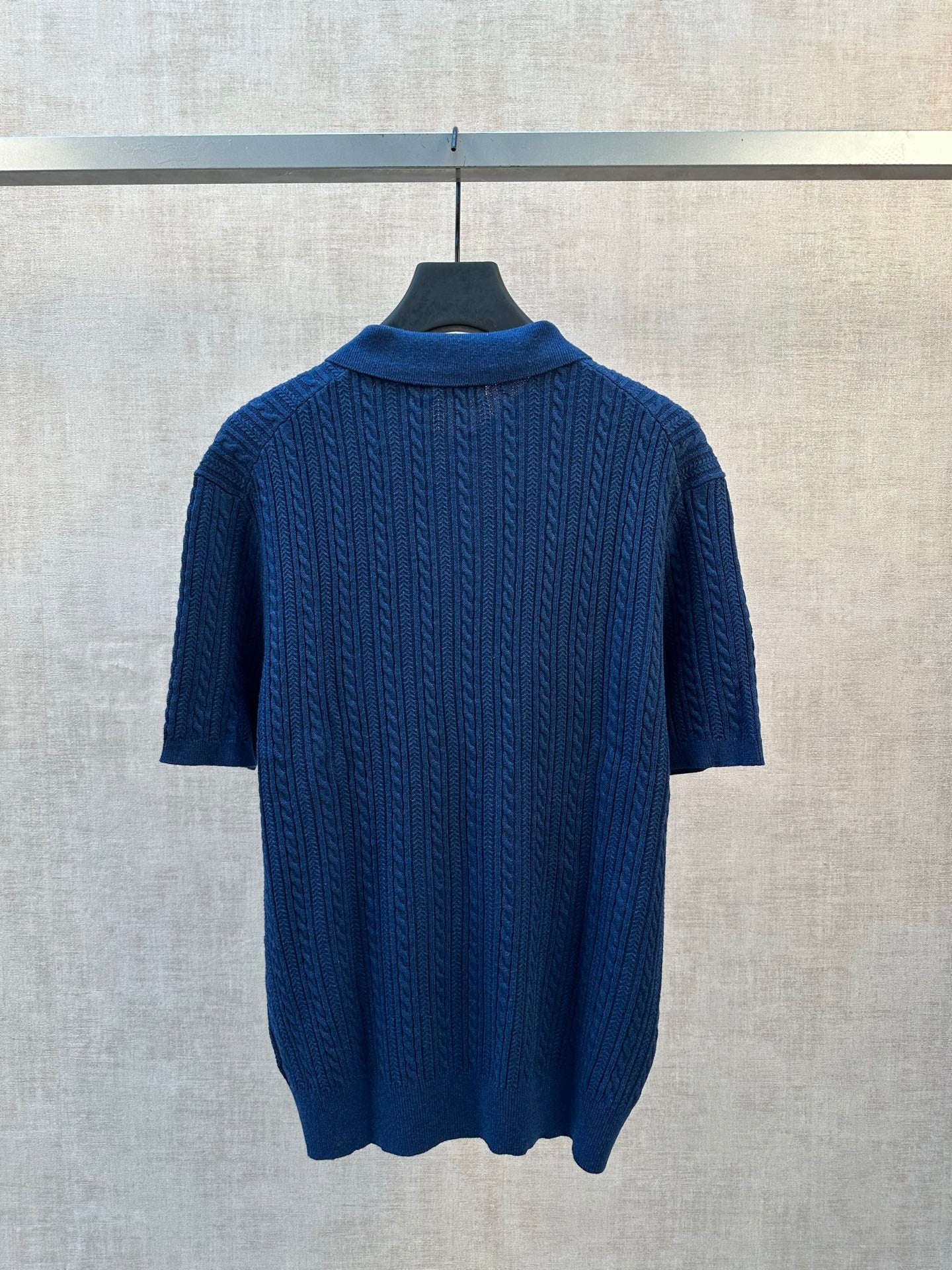 Blue cable-knit polo shirt back view with ribbed collar and short sleeves