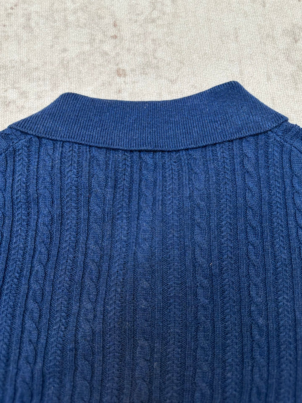 Blue cable-knit polo shirt back yoke with ribbed collar