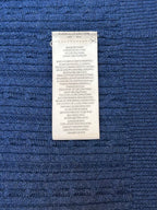 Blue polo shirt care label sewn into fabric
