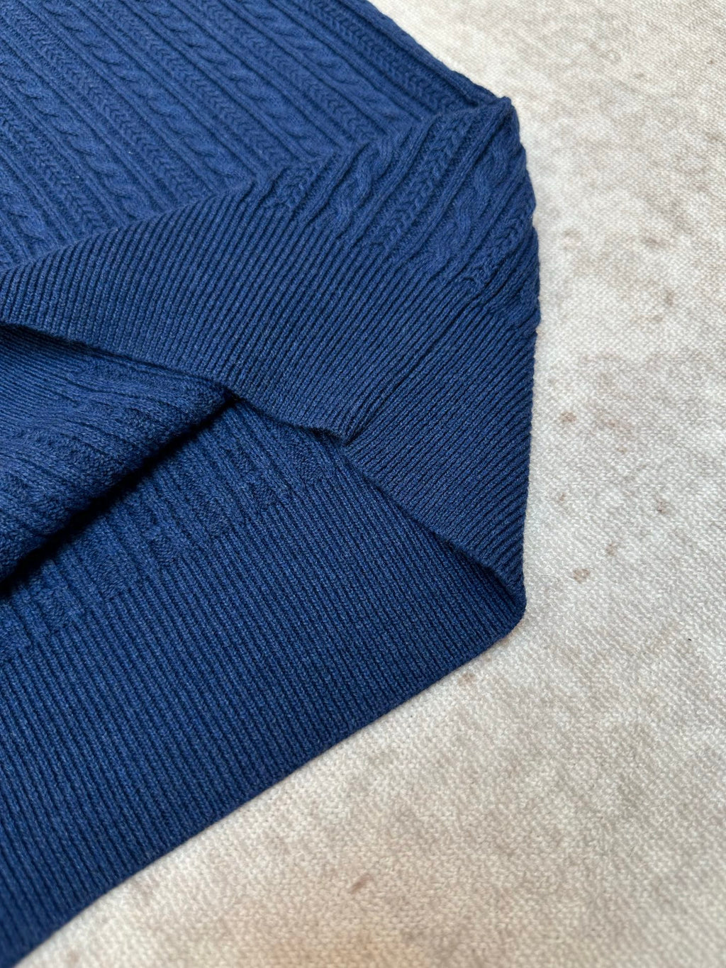 Blue knit polo shirt shoulder seam and ribbed collar detail