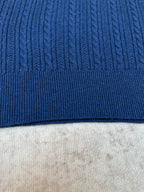 Blue knit polo shirt hem with ribbed trim and cable texture