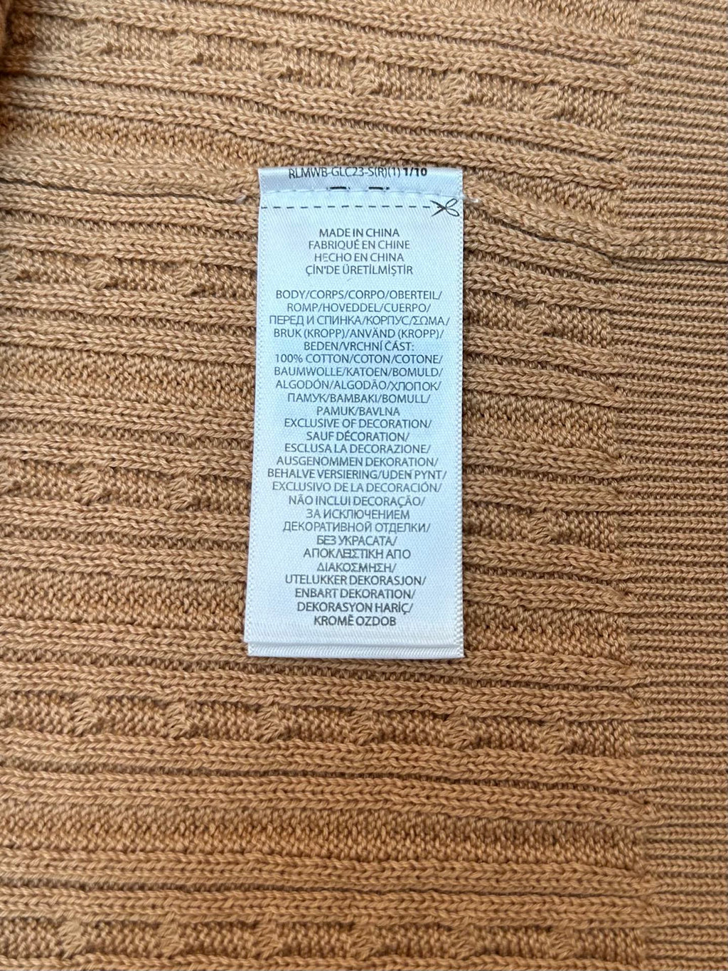Tan knit polo care label sewn into inner hem