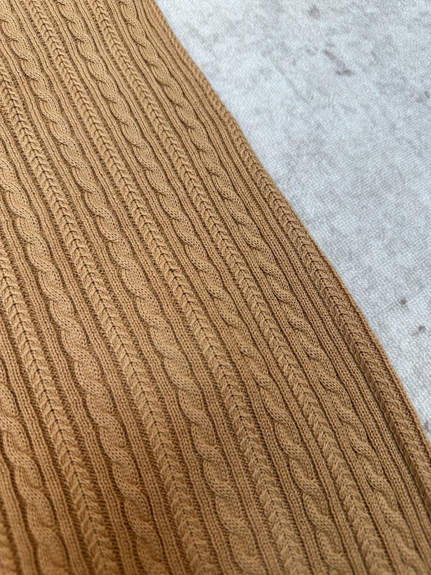 Tan cable-knit polo sleeve close-up with cable stitch pattern