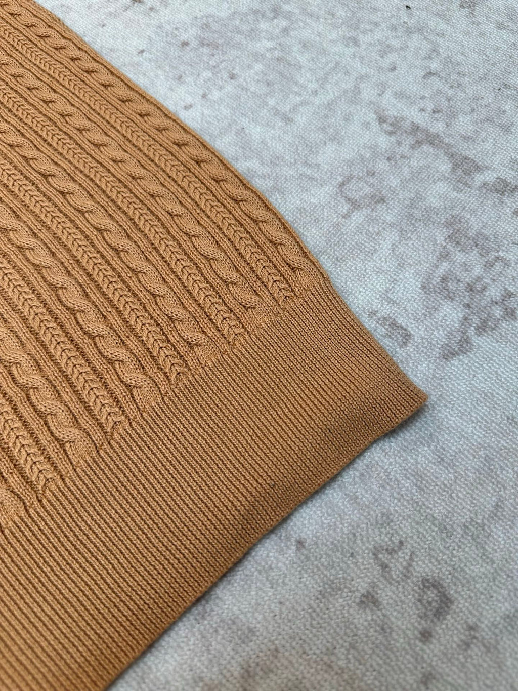 Tan cable-knit polo sleeve and side hem detail