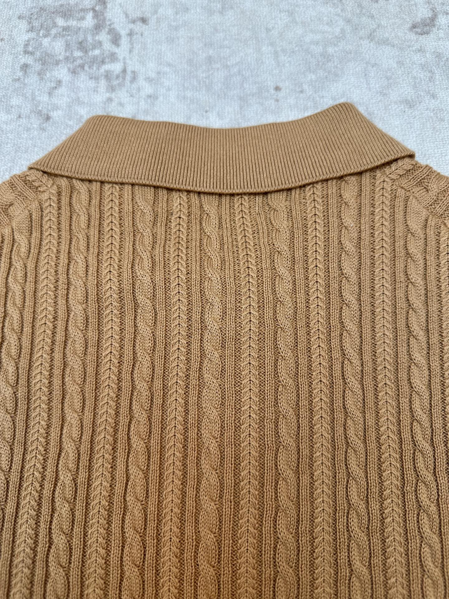 Tan cable-knit polo back with ribbed collar and vertical knit texture