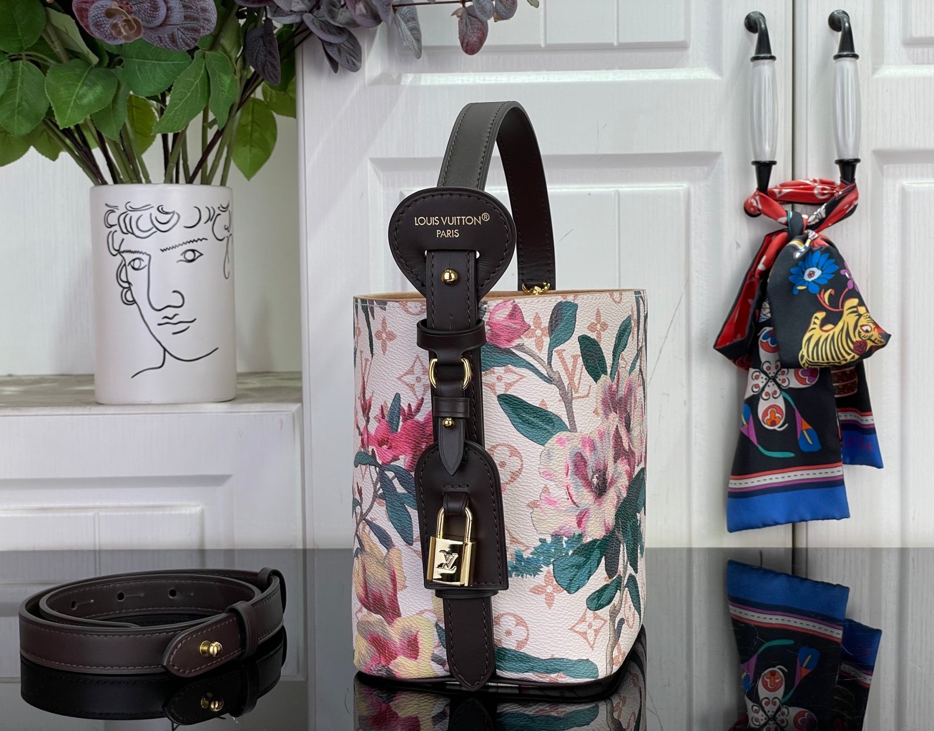 Louis Vuitton bucket-style bag with floral canvas, black leather trim and hanging strap