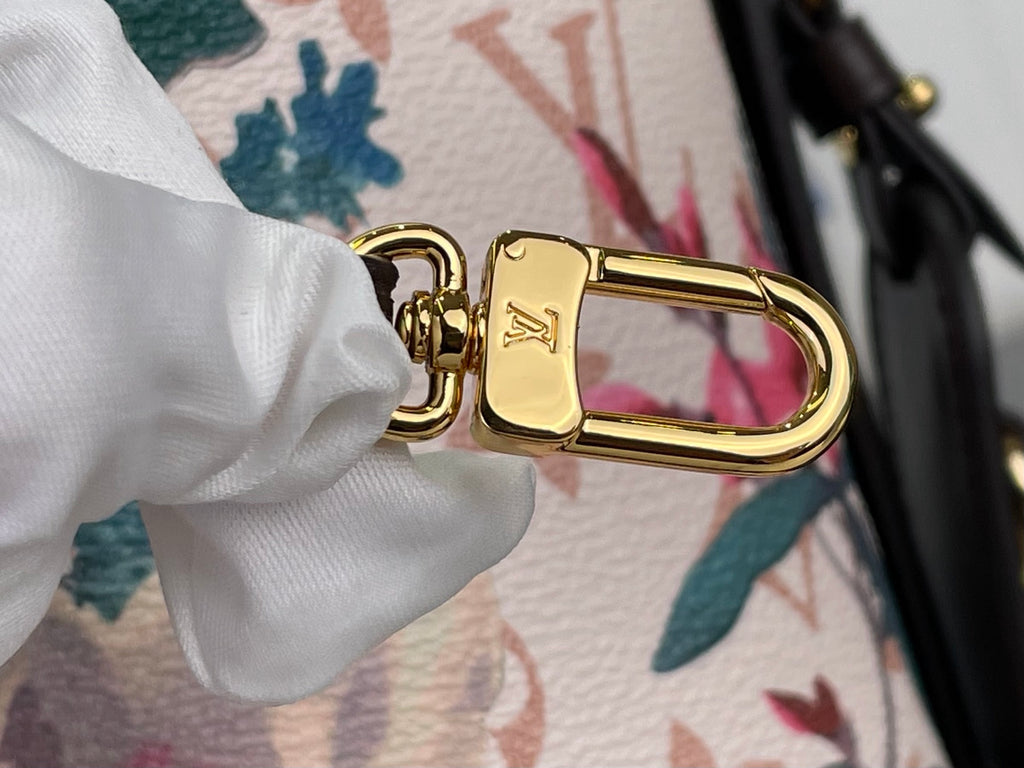 Louis Vuitton bag clasp closeup with gold hardware and LV emblem on floral strap