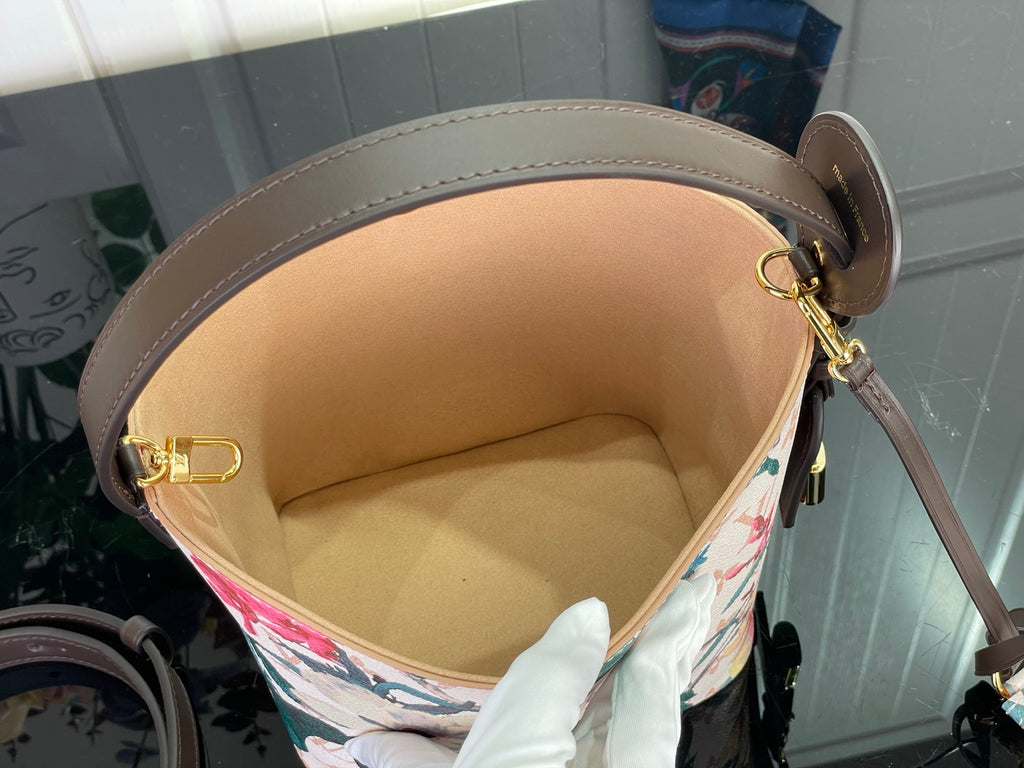 Louis Vuitton bag interior view with tan lining and brown leather top edge with gold ring