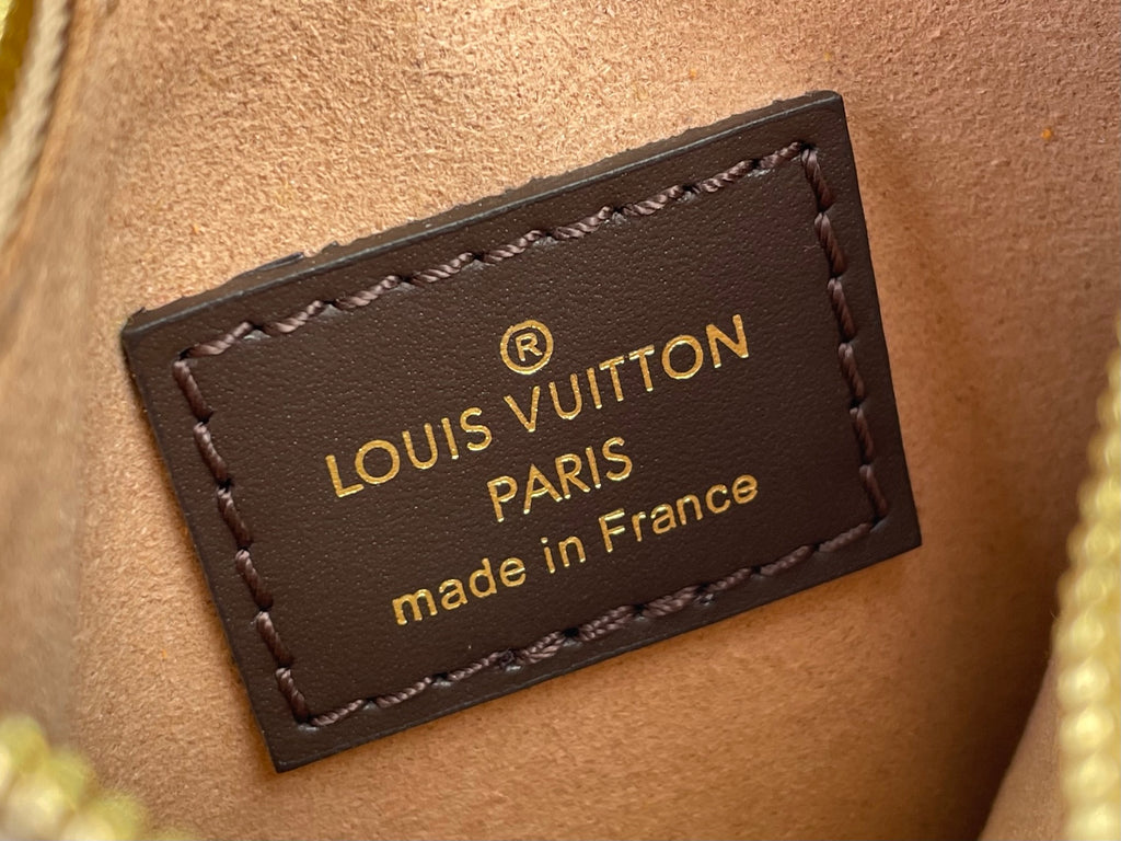 Louis Vuitton leather logo patch with gold text on brown background, stitched edges