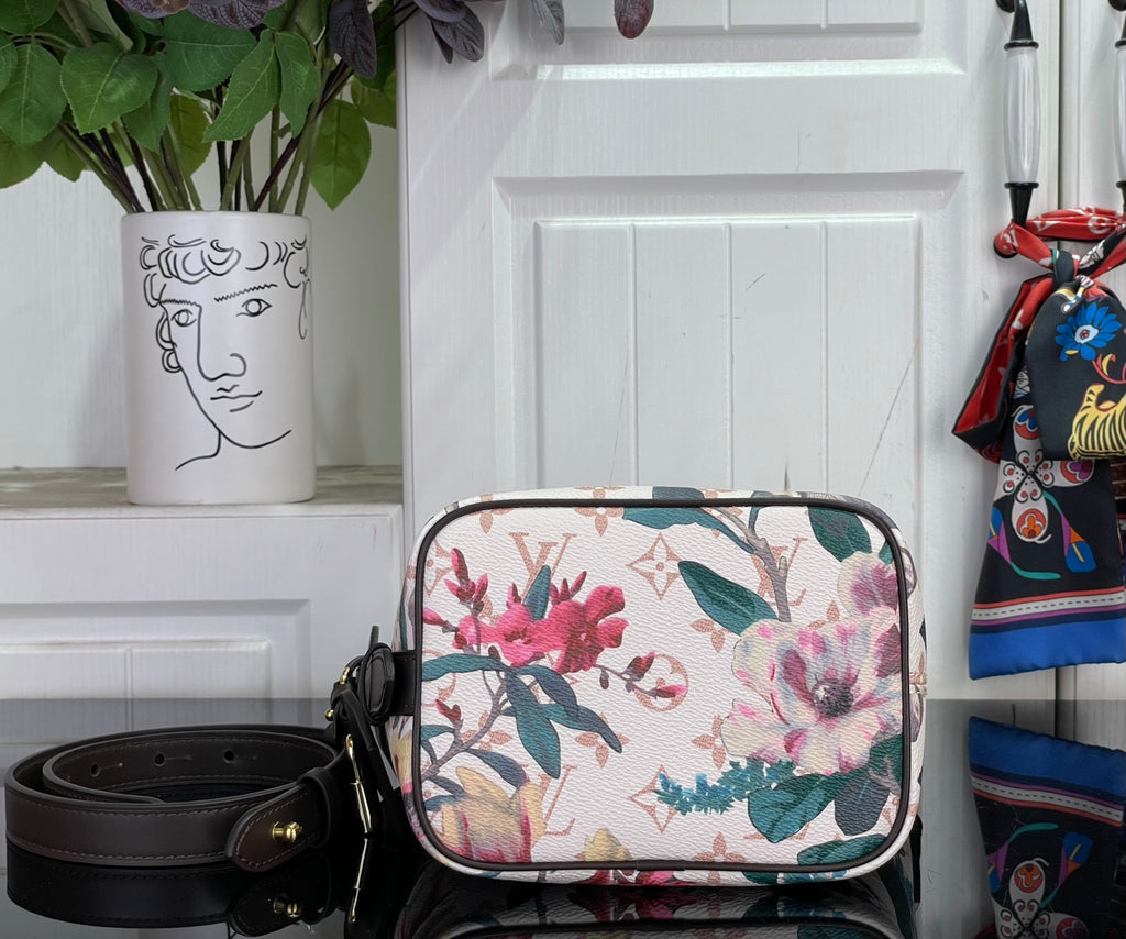 Louis Vuitton crossbody bag with floral canvas and black top frame, front view