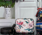 Louis Vuitton crossbody bag with floral canvas and black top frame, front view
