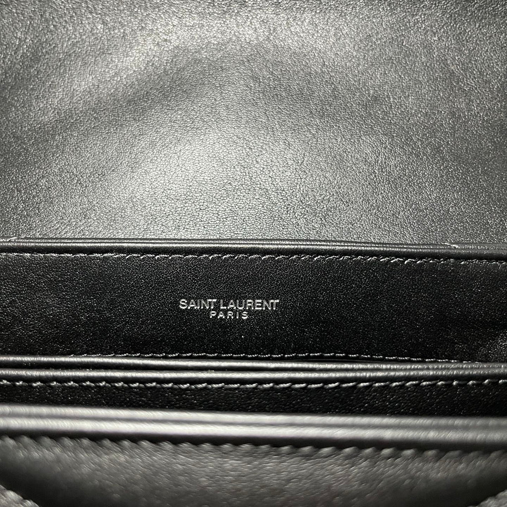 YSL bag close-up of stitched edge with embossed “SAINT LAURENT PARIS” text