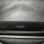 YSL bag close-up of stitched edge with embossed “SAINT LAURENT PARIS” text