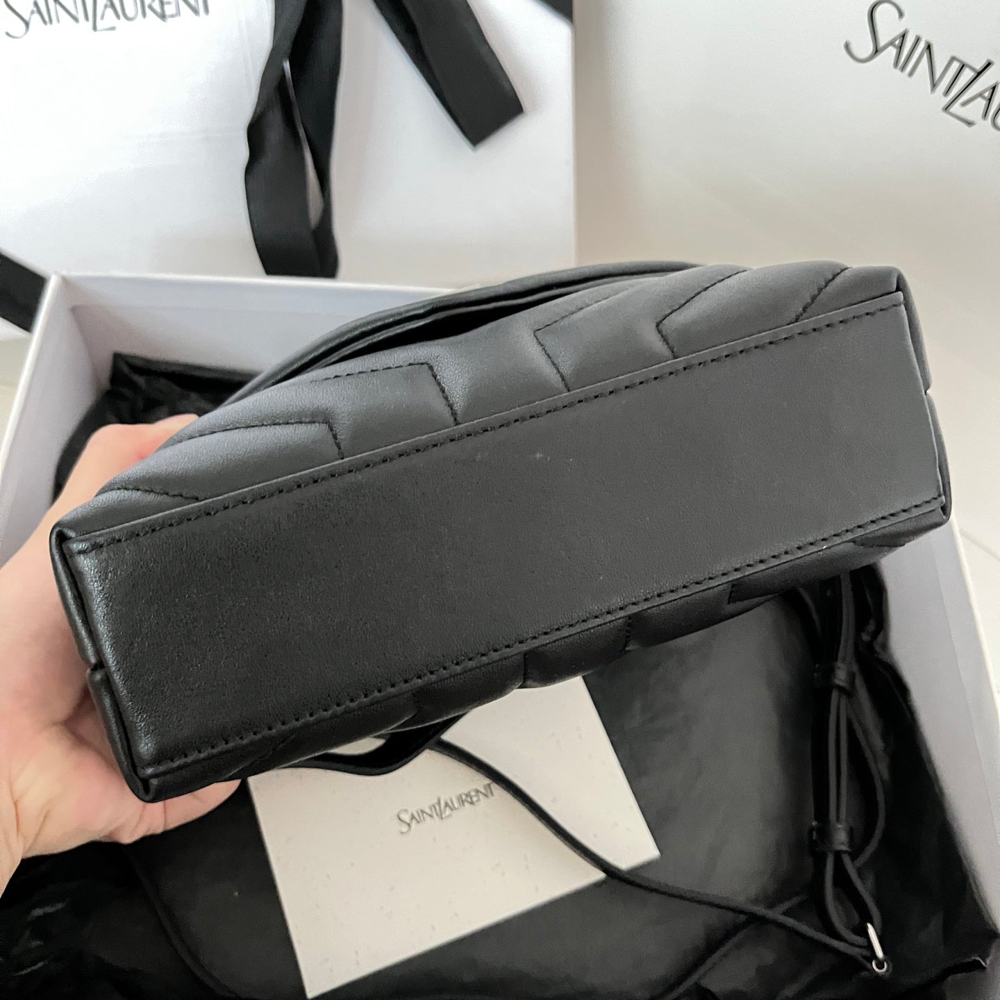 YSL bag side profile with smooth top edge and dark leather strap attachment