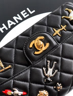Chanel quilted black bag close-up with gold emblem and silver charm details