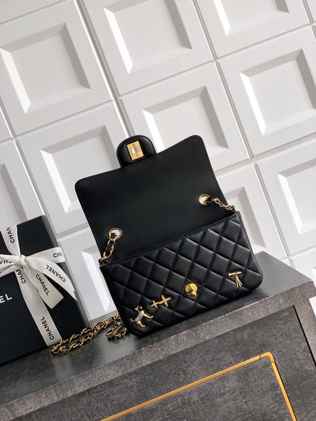 Chanel bag in black with gold clasp, quilted front panel, and chain strap