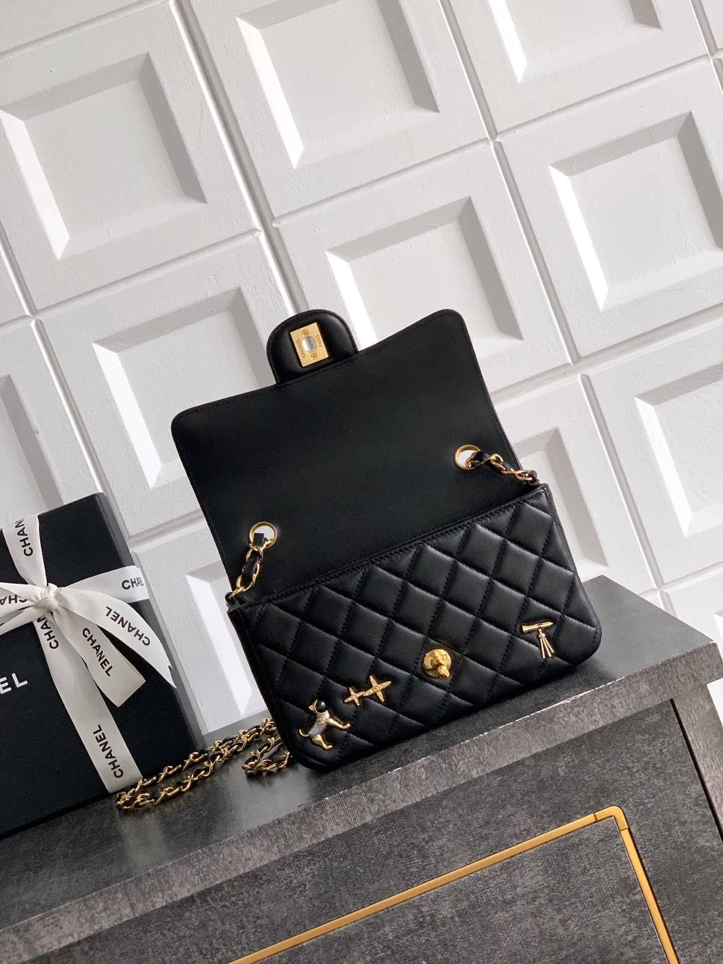 Chanel bag in black with gold clasp, quilted front panel, and chain strap